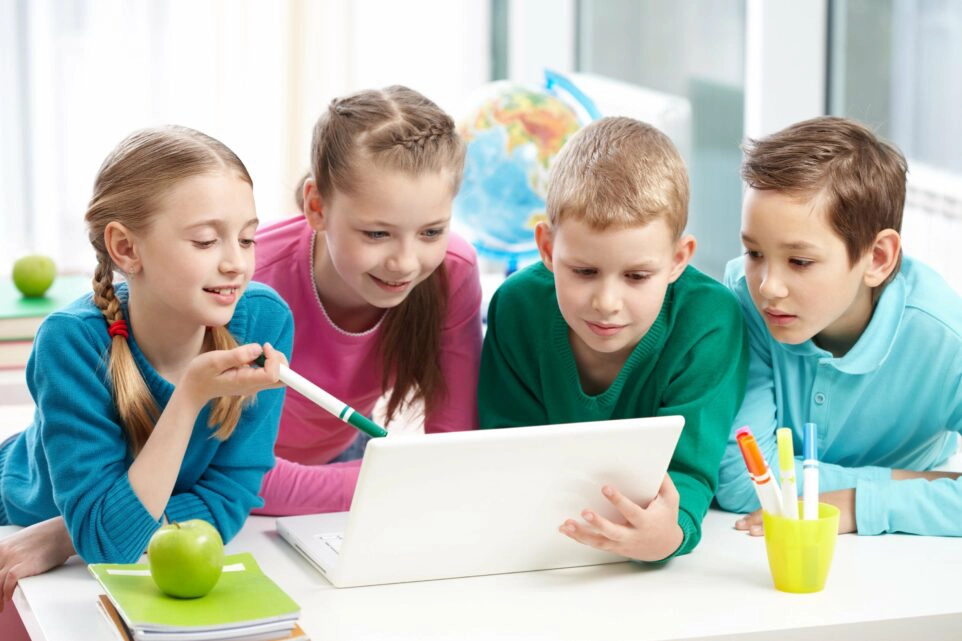 Vier Kinder vor eine Laptop um den richtigen Umgang in der digitalen Welt zu lernen